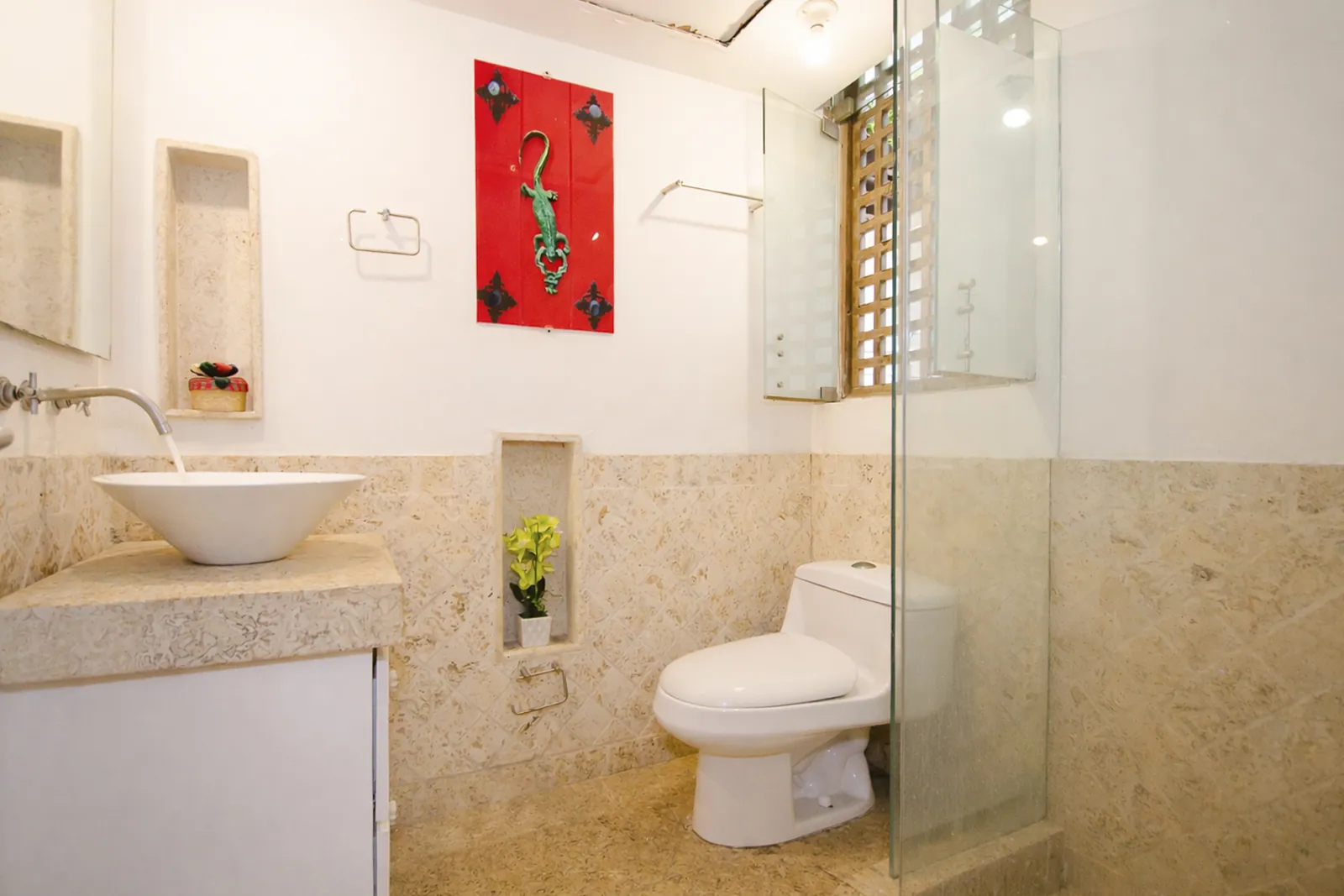 Salle de bain en pierre coralienne avec douche à l'italienne