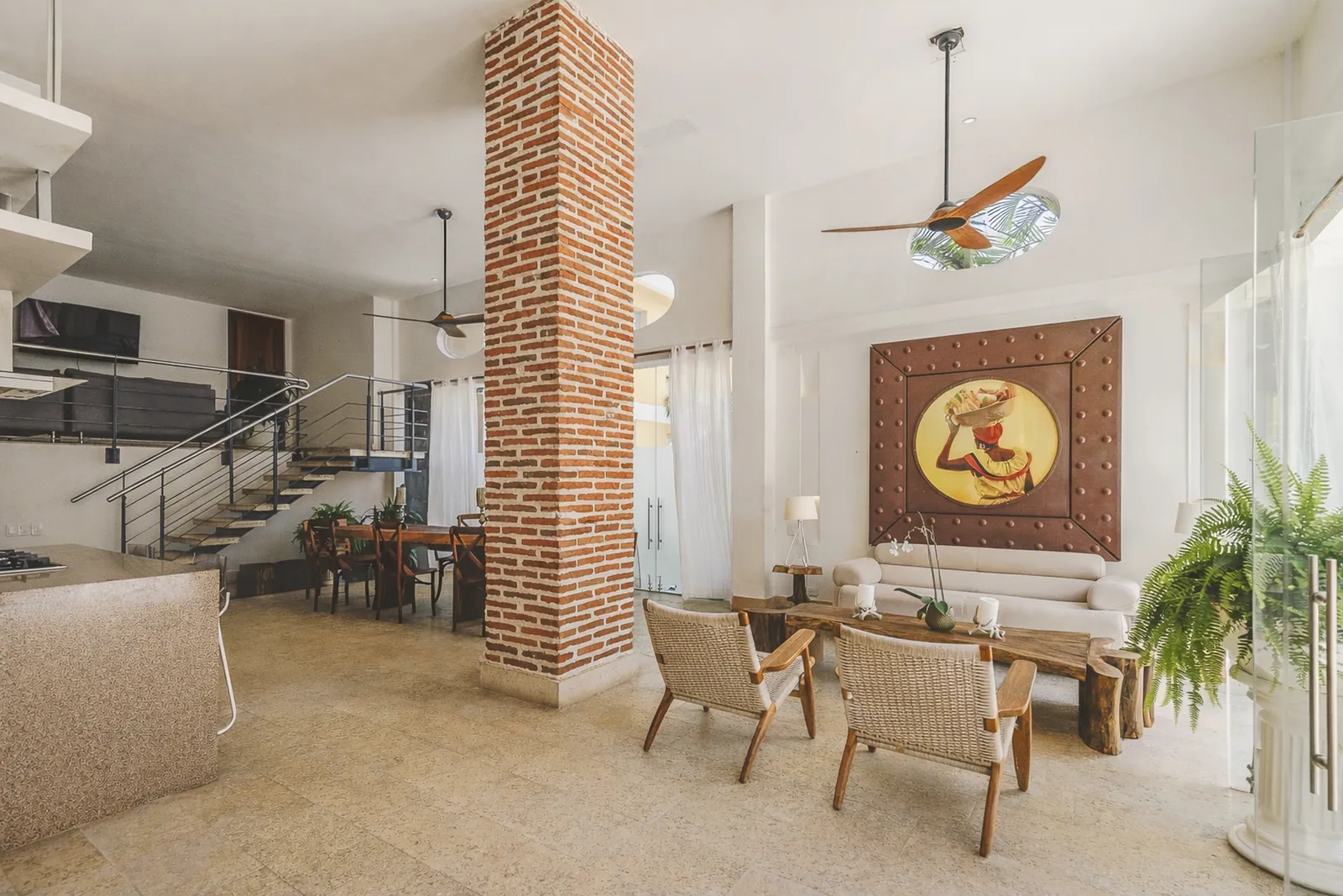 Salon et salle à manger aux murs de brique apparente et plafonds de 4 m
